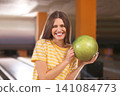 Young woman with ball in bowling club Young woman with ball in bowling club 141084773