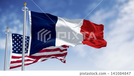 National flags of France and USA waving in the wind on a clear day National flags of France and USA waving in the wind on a clear day 141084847