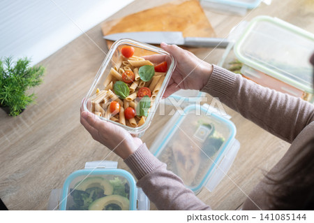 Woman holding a healthy pasta meal prep container Woman holding a healthy pasta meal prep container 141085144
