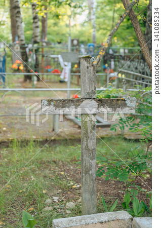 serene wooden cross standing upright in a cemetery with a metal fence and flowers, ground-level perspective, green and brown tones, religious imagery, memorial photography, cemetery scenes. serene wooden cross standing upright in a cemetery with a metal fence and flowers, ground-level perspective, green and brown tones, religious imagery, memorial photography, cemetery scenes. 141085234
