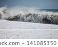 Ocean wave exploding into windblown spray 141085350