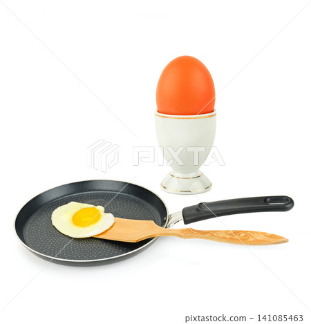 Fried Egg in a Frying Pan and Raw Brown Egg in Cup Isolated on White Healthy Breakfast Cooking Concept with Fried and Whole Eggs Fried Egg in a Frying Pan and Raw Brown Egg in Cup Isolated on White Healthy Breakfast Cooking Concept with Fried and Whole Eggs 141085463