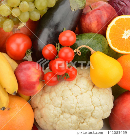 A vibrant assortment of ripe fruits and crisp vegetables forms a dense, colorful background pattern. 141085469