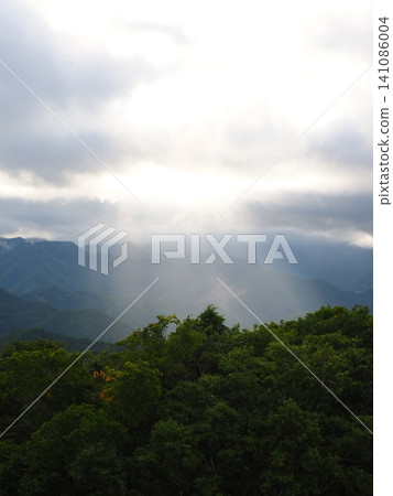 陽光穿透雲層和青山。 陽光穿透雲層和青山。 141086004