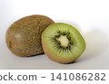 Whole kiwi fruit next to a fresh cut half on white background. 141086282