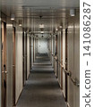 Long narrow corridor inside a cruise ship or hotel with wooden doors. 141086287