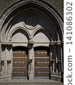 Ancient Wooden Doors of a Gothic Church with Stone Arch 141086302