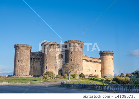Naples, italy. December 27, 2024. Castel nuovo, also known as maschio angioino, stands under a clear blue sky, presenting its robust medieval architecture and turrets Naples, italy. December 27, 2024. Castel nuovo, also known as maschio angioino, stands under a clear blue sky, presenting its robust medieval architecture and turrets 141086735