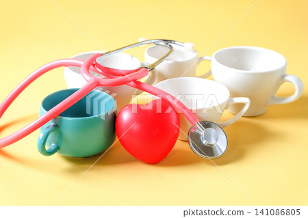 Pink stethoscope on different cups and mugs of coffee. Pink stethoscope on different cups and mugs of coffee. 141086805
