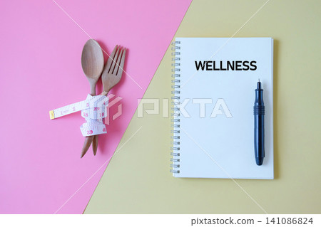 Text WELLNESS write on notebook and pen,health concept. Text WELLNESS write on notebook and pen,health concept. 141086824