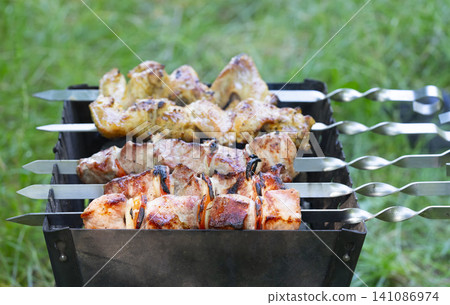 Grilling shashlik for a backyard gathering with friends and family 141086974