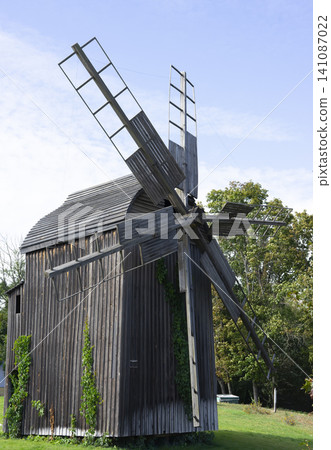 Old medieval windmill in a serene field under a clear blue sky 141087022