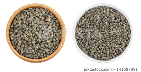 raw french green lentils in wooden and ceramic bowl and scoop isolated on white background. Top view. Flat lay raw french green lentils in wooden and ceramic bowl and scoop isolated on white background. Top view. Flat lay 141087951
