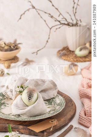 Stylish Easter brunch table setting with egg in easter bunny napkin. Stylish Easter brunch table setting with egg in easter bunny napkin. 141087989