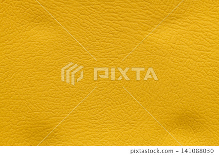 Full-frame macro shot detailing the distinctive, finely textured surface of a bright and vivid mustard yellow leather material Full-frame macro shot detailing the distinctive, finely textured surface of a bright and vivid mustard yellow leather material 141088030