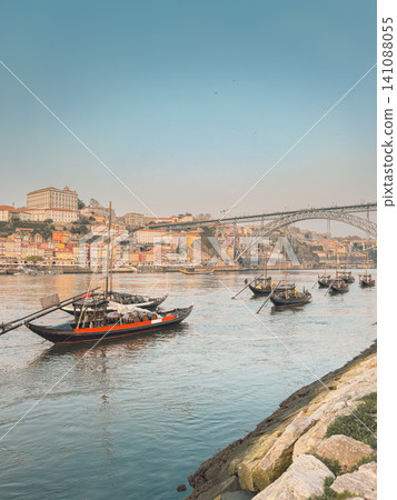 Traditional Rabelo boats, once used to transport port wine along the Douro River, now symbolize Portugal s rich winemaking heritage. Traditional Rabelo boats, once used to transport port wine along the Douro River, now symbolize Portugal s rich winemaking heritage. 141088055