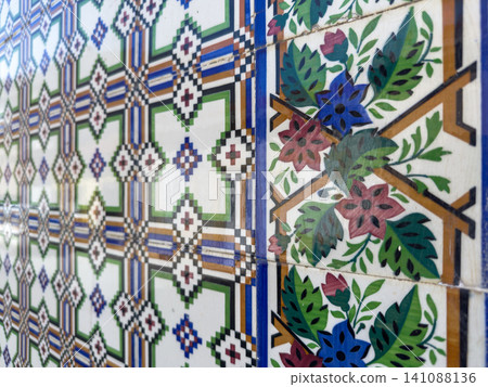 Vibrant Portuguese ceramic wall tiles featuring intricate floral patterns and geometric designs, capturing the artistic heritage of traditional azulejos 141088136