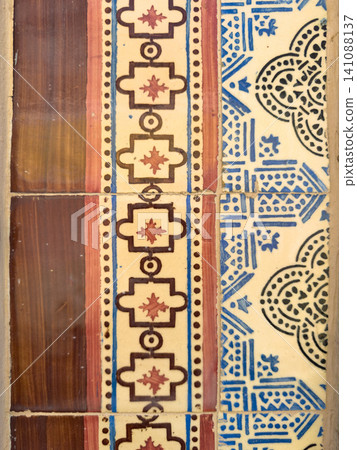 Close-up of traditional Portuguese ceramic tiles featuring geometric patterns in brown and blue colors, showcasing historic azulejo architecture Close-up of traditional Portuguese ceramic tiles featuring geometric patterns in brown and blue colors, showcasing historic azulejo architecture 141088137
