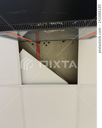 Open ceiling with removed tile, exposing pipes and dark server cabinet on the side Open ceiling with removed tile, exposing pipes and dark server cabinet on the side 141088185