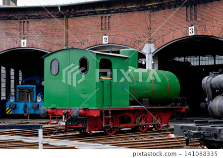 Rare Green Fireless Steam Locomotive Parked on Rails Near a Brick Roundhouse Building Rare Green Fireless Steam Locomotive Parked on Rails Near a Brick Roundhouse Building 141088335