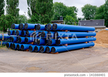 Heavy duty blue plastic industrial pipelines stacked on ground Heavy duty blue plastic industrial pipelines stacked on ground 141088401