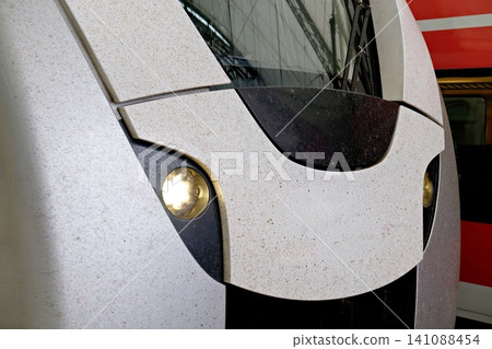 Front view of modern train cabin with illuminated symmetrical headlights and speckled surface Front view of modern train cabin with illuminated symmetrical headlights and speckled surface 141088454
