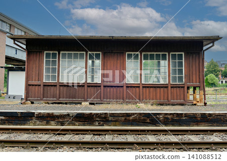 Old vintage brown wooden railway station building cabin next to tracks Old vintage brown wooden railway station building cabin next to tracks 141088512