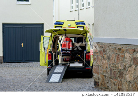 Close up of an open yellow ambulance van with extended ramp on cobblestones Close up of an open yellow ambulance van with extended ramp on cobblestones 141088537