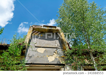 Ruined building facade surrounded by green trees under a bright blue sky Ruined building facade surrounded by green trees under a bright blue sky 141088553
