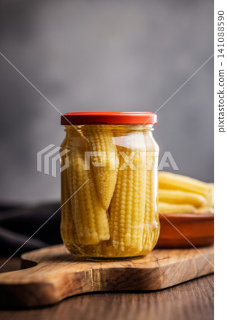 Jar Of Pickled Baby Corn In Glass Preserved On Wooden Board . Canned Food Closeup Jar Of Pickled Baby Corn In Glass Preserved On Wooden Board . Canned Food Closeup 141088590