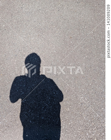 Silhouettes of people reflected on a paved road; background material that evokes self-expression and everyday life. Silhouettes of people reflected on a paved road; background material that evokes self-expression and everyday life. 141089209