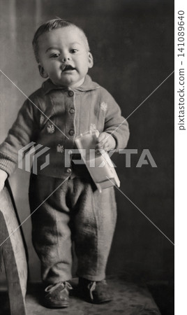 Happy Toddler Holding a Toy Car While Standing on a Small Chair Happy Toddler Holding a Toy Car While Standing on a Small Chair 141089640