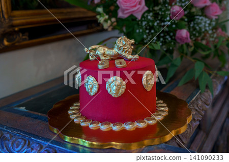 Red velvet cake with golden lion and coin decorations Red velvet cake with golden lion and coin decorations 141090233