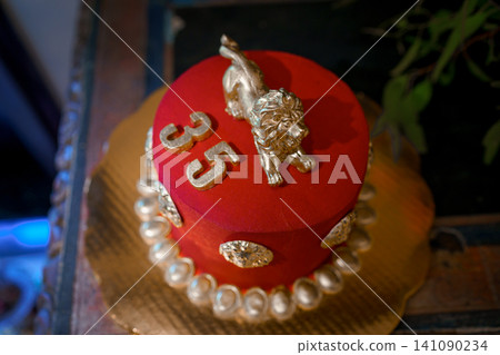 Red velvet cake with golden lion and coin decorations Red velvet cake with golden lion and coin decorations 141090234