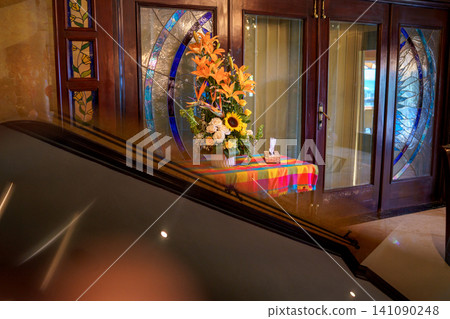 Colorful flower arrangement on table by stained glass Colorful flower arrangement on table by stained glass 141090248