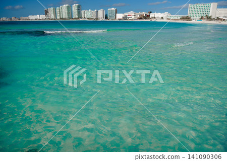Turquoise ocean water with city hotels on horizon Turquoise ocean water with city hotels on horizon 141090306