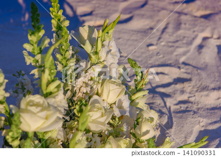 White roses and snapdragons bouquet on sandy beach White roses and snapdragons bouquet on sandy beach 141090331
