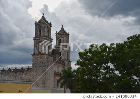 Ancient stone church bell towers against stormy clouds 141090334