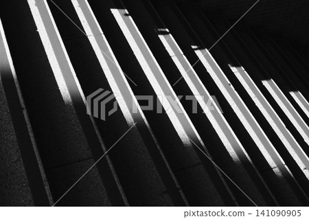 A monochrome photograph of the diagonal light and shadow on a staircase, created by strong sunlight. A monochrome photograph of the diagonal light and shadow on a staircase, created by strong sunlight. 141090905
