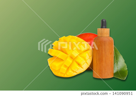 Fresh mango slices and essential oil bottle showcase tropical flavors 141090951