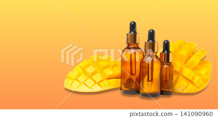 Bottles filled with mango oil rest beside sliced mango fruit Bottles filled with mango oil rest beside sliced mango fruit 141090960