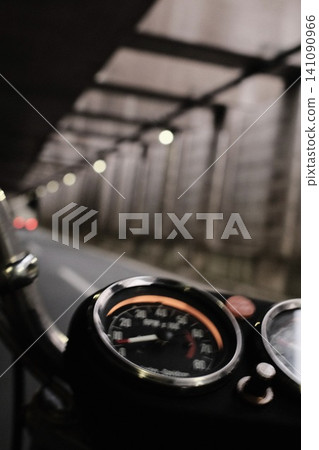 Close-up of the instrument panel of a motorcycle going through a tunnel. Close-up of the instrument panel of a motorcycle going through a tunnel. 141090966