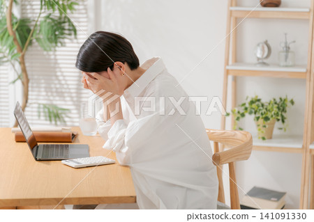 A woman struggling with a calculator. 141091330