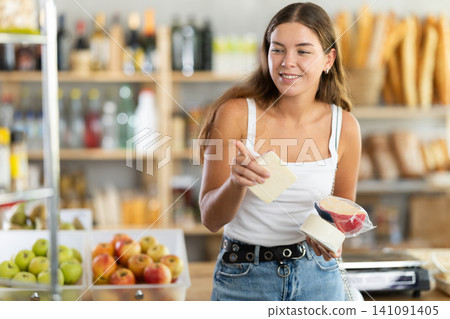 Young woman choosing cheese in grocery store Young woman choosing cheese in grocery store 141091405