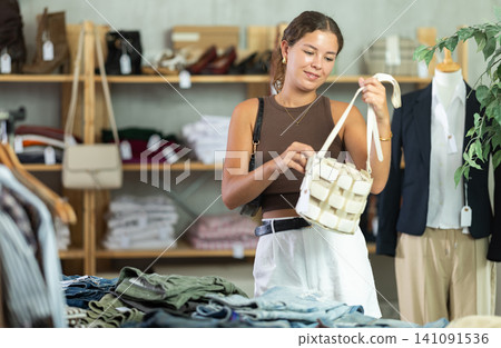 Woman choosing handbags in the store Woman choosing handbags in the store 141091536