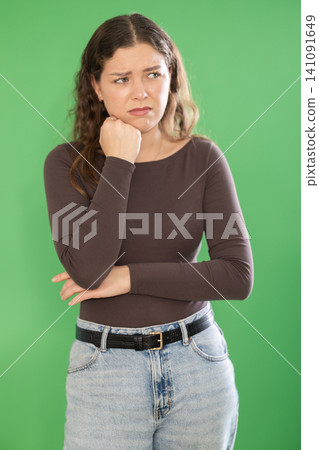 Young woman sad and upset in front of green screen Young woman sad and upset in front of green screen 141091649