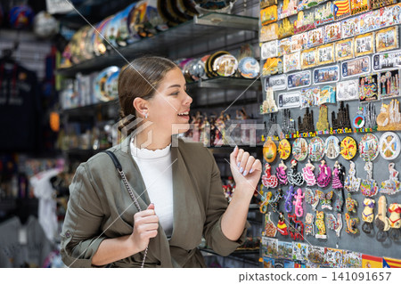 Portrait of happy woman choosing souvenirs at street market city. Spain Portrait of happy woman choosing souvenirs at street market city. Spain 141091657