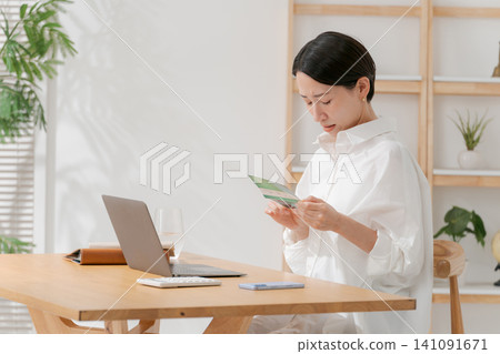 A woman who falls down looking at a passbook A woman who falls down looking at a passbook 141091671