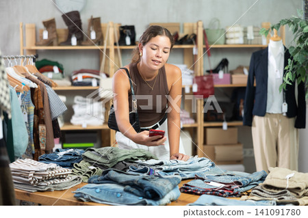 Woman scanning jeans in store Woman scanning jeans in store 141091780