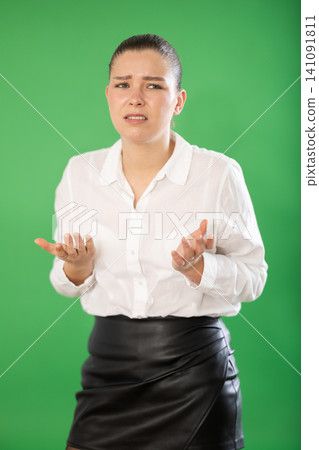 Sad woman standing on the green background Sad woman standing on the green background 141091811